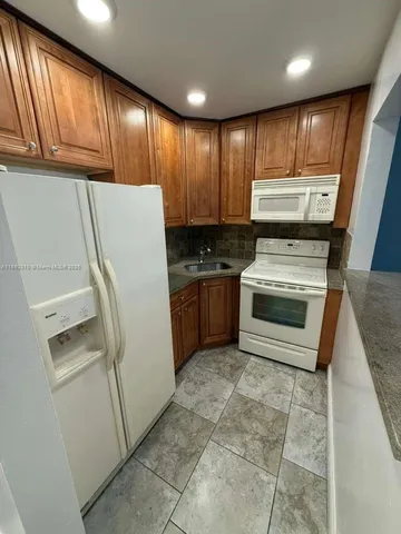 a kitchen with a refrigerator sink and cabinets