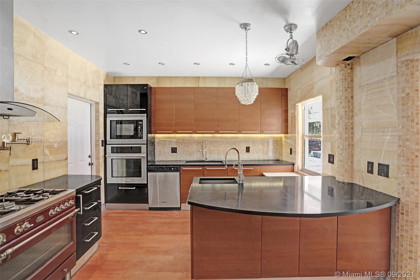 4431 Alton Road Miami Beach, FL 33140 - Photo 11 of 58 a kitchen with stainless steel appliances granite countertop a sink a stove and a refrigerator