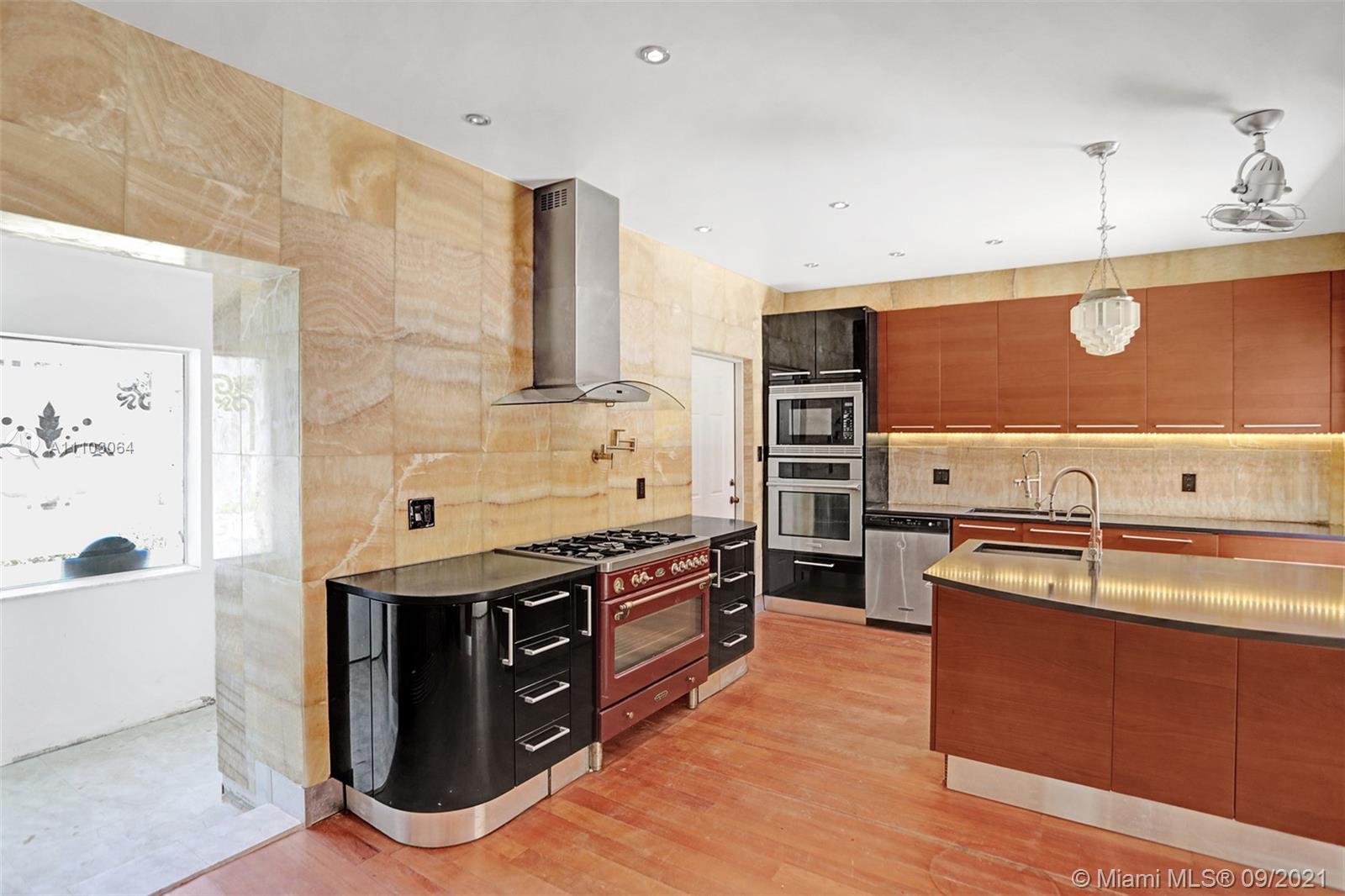 4431 Alton Road Miami Beach, FL 33140 - Photo 12 of 58 a kitchen with stainless steel appliances granite countertop a stove and a sink