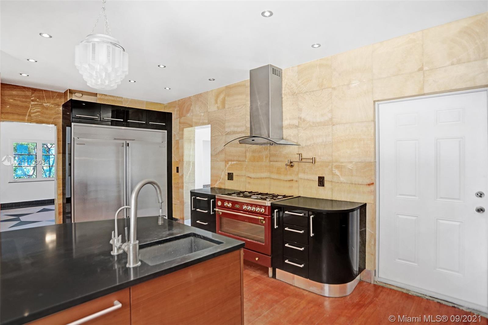 4431 Alton Road Miami Beach, FL 33140 - Photo 14 of 58 a kitchen with stainless steel appliances granite countertop a sink a stove and a refrigerator
