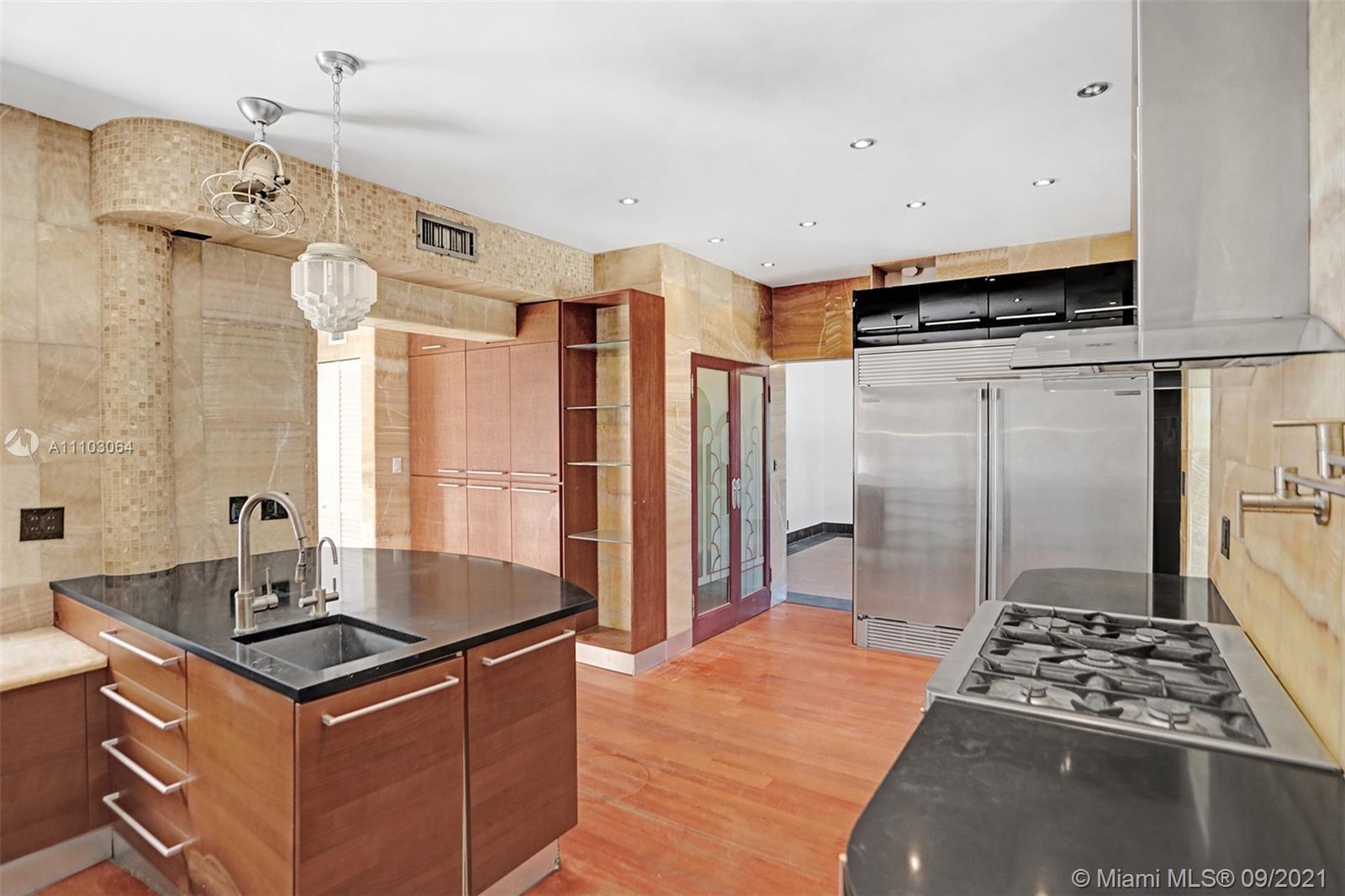 4431 Alton Road Miami Beach, FL 33140 - Photo 15 of 58 a kitchen with stainless steel appliances granite countertop a sink stove and refrigerator