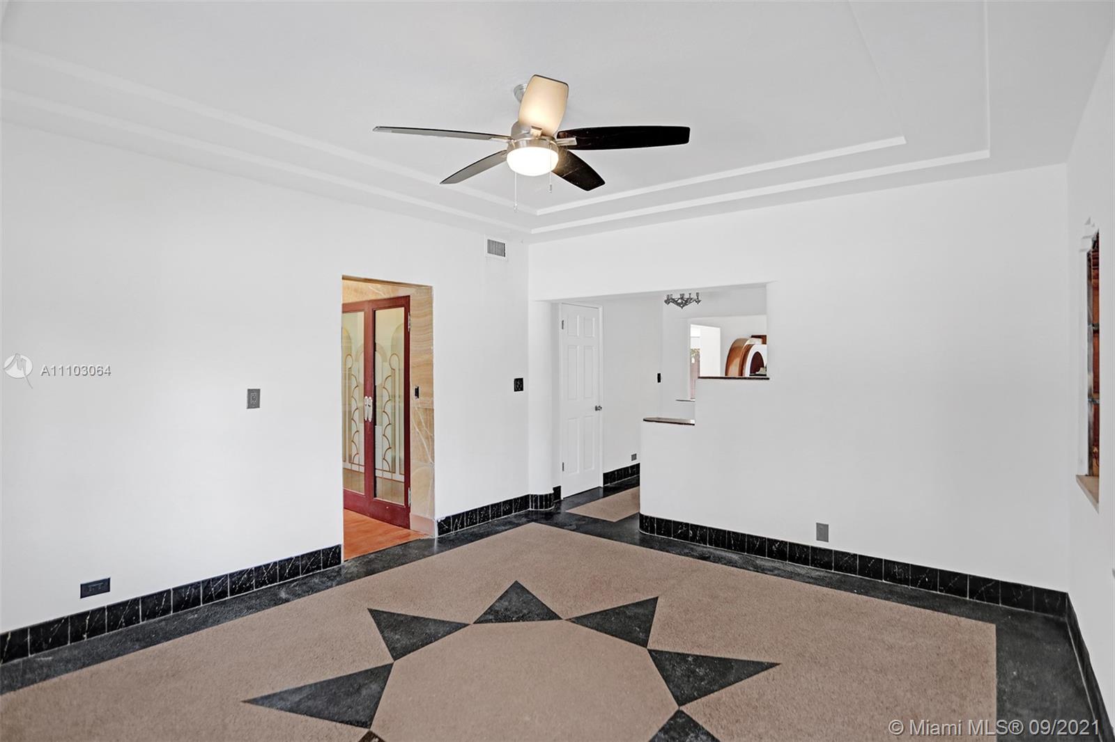 4431 Alton Road Miami Beach, FL 33140 - Photo 18 of 58 a room with gym equipment and a ceiling fan