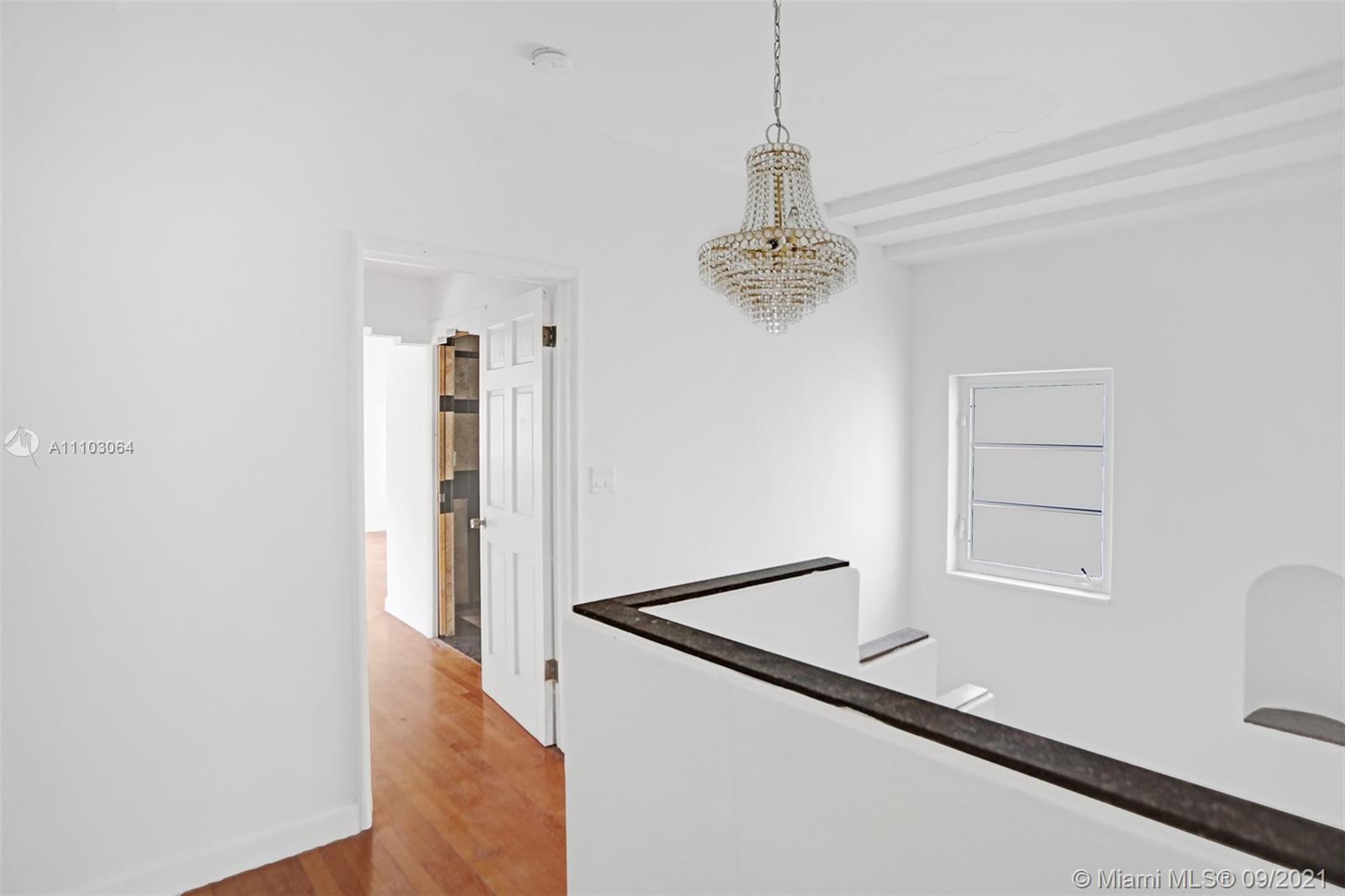 4431 Alton Road Miami Beach, FL 33140 - Photo 24 of 58 a view of a hallway with wooden floor and staircase