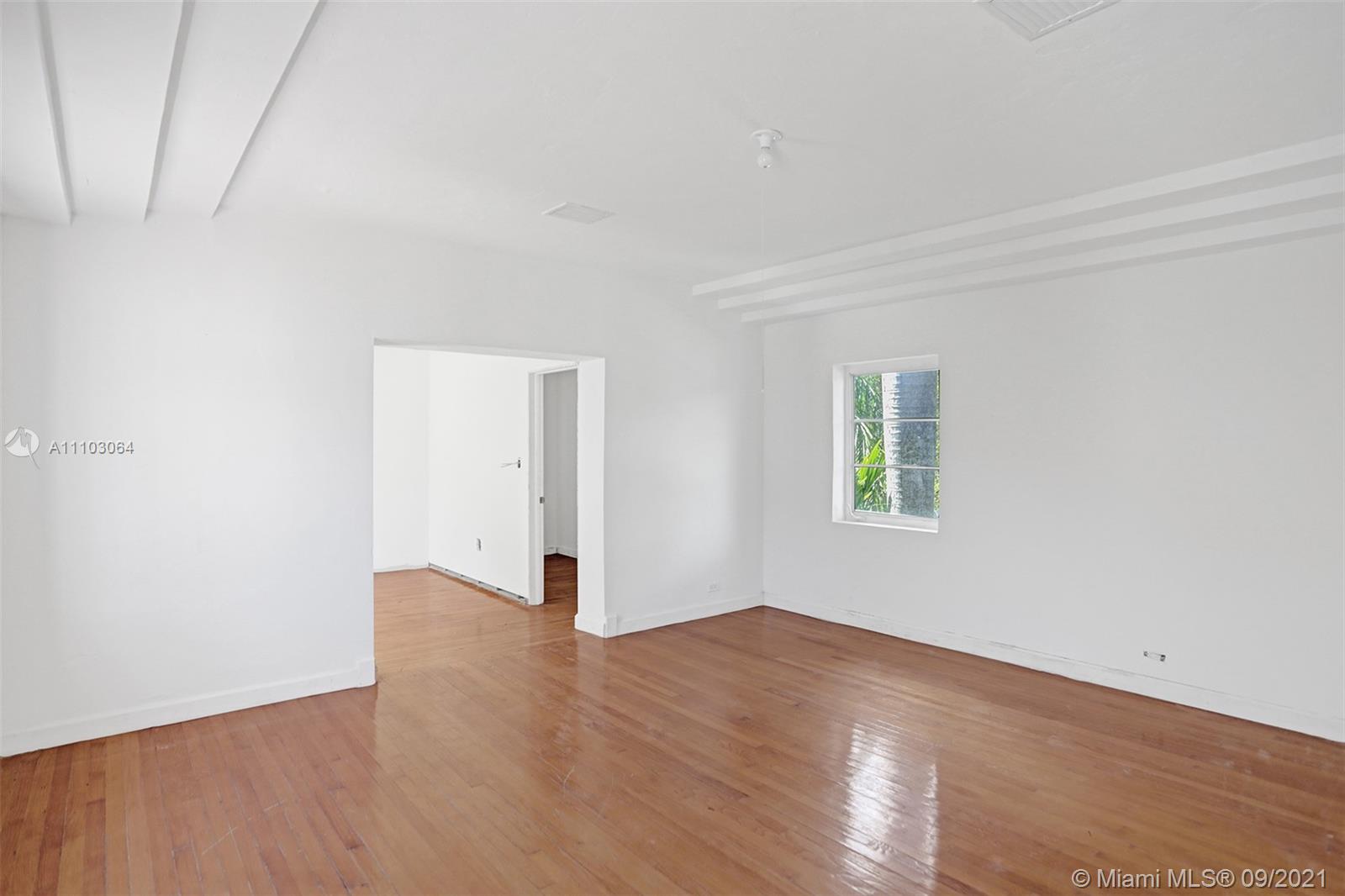 4431 Alton Road Miami Beach, FL 33140 - Photo 27 of 58 a view of an empty room with wooden floor and a window