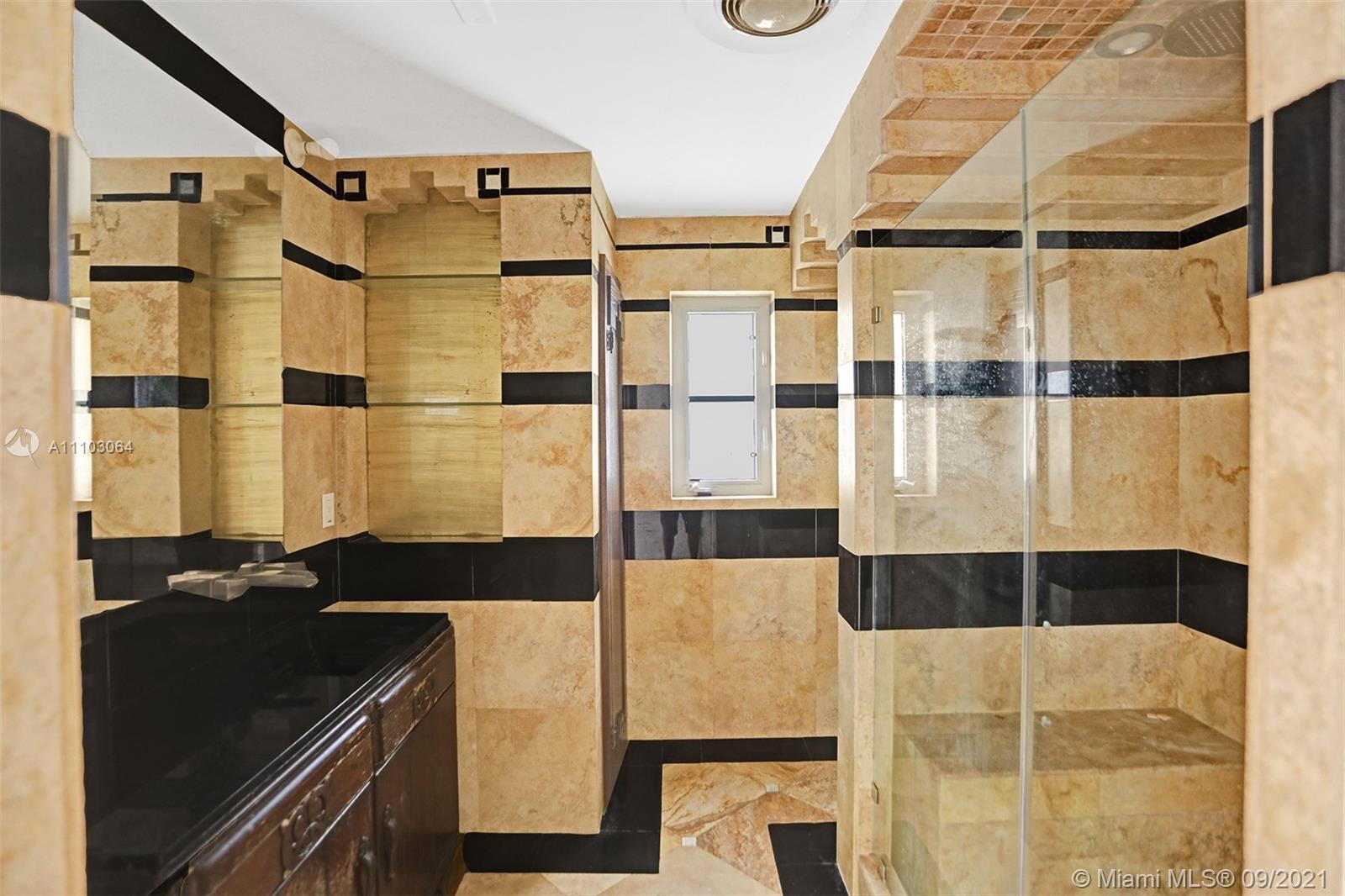 4431 Alton Road Miami Beach, FL 33140 - Photo 30 of 58 a bathroom with a black and white shower curtain