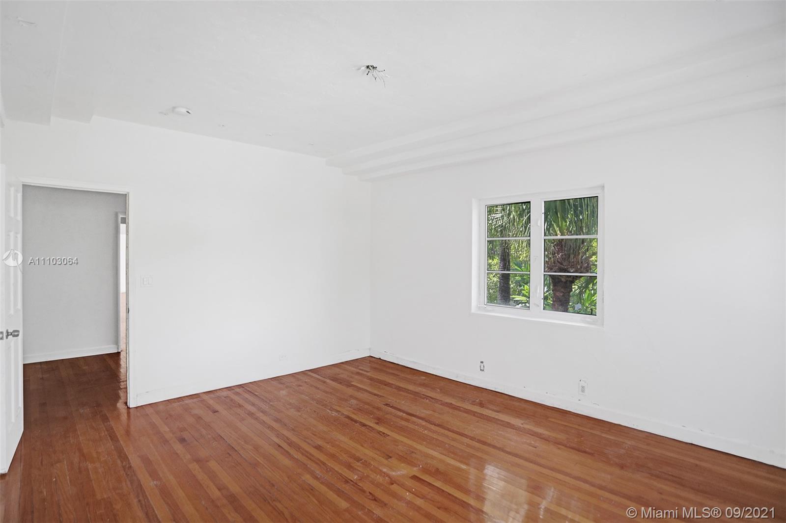 4431 Alton Road Miami Beach, FL 33140 - Photo 34 of 58 an empty room with wooden floor and windows