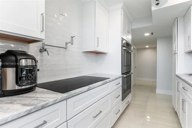 a kitchen with granite countertop a sink stainless steel appliances and cabinets
