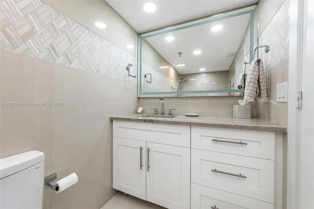 a bathroom with a sink a toilet and a mirror