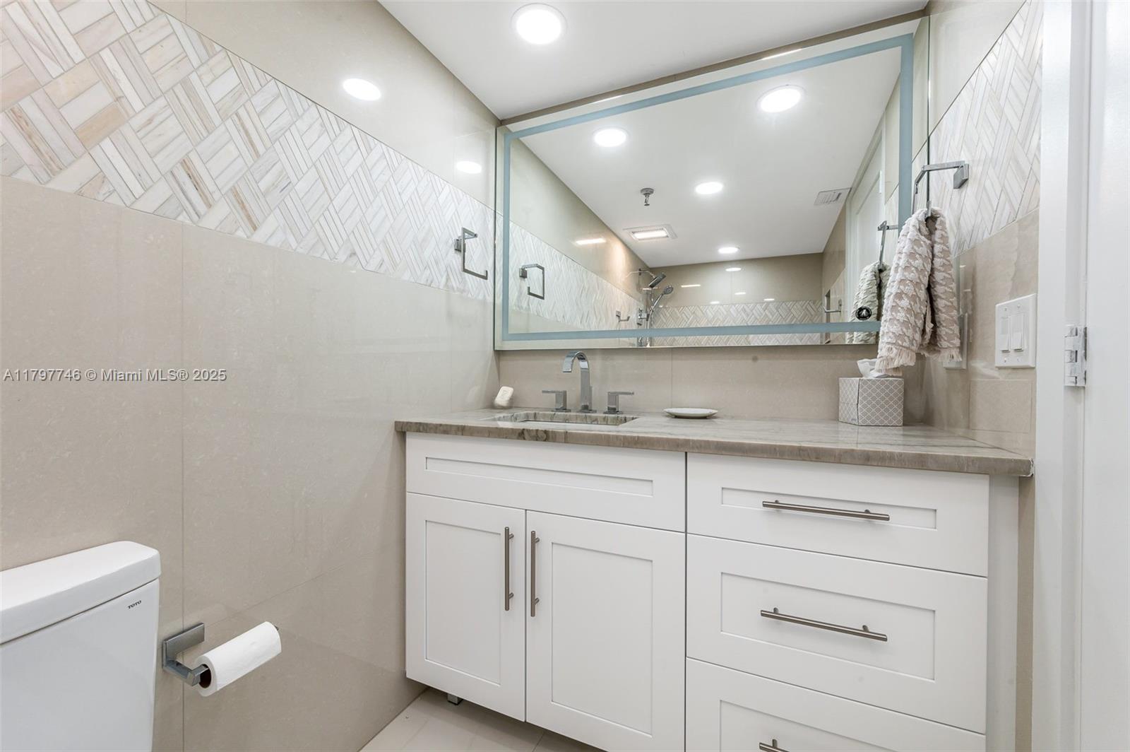3912 South Ocean Boulevard, Unit 306 Highland Beach, FL 33487 - Photo 7 of 25 a bathroom with a sink a toilet and a mirror