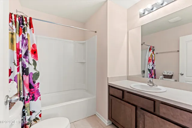 a bathroom with a sink vanity mirror and a bathtub