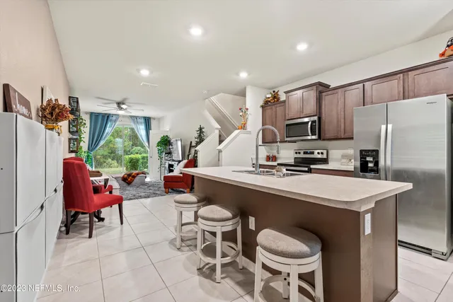 a kitchen with a sink a table and chairs in it