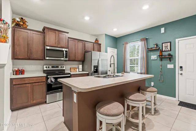 a kitchen with a stove a sink a dining table and chairs