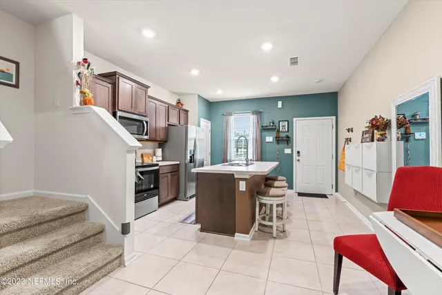 a living room with furniture and a kitchen view