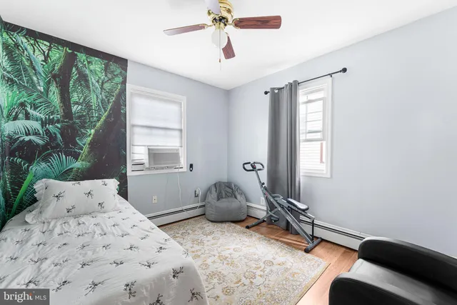 a bedroom with a bed and large windows