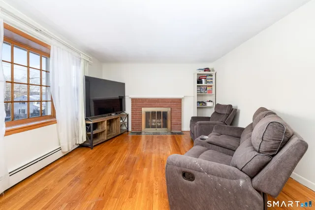 a living room with furniture a flat screen tv and a fireplace
