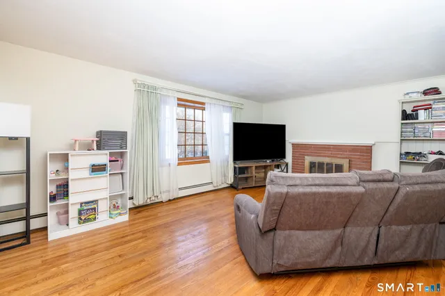 a living room with furniture a flat screen tv and a book shelf