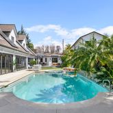 a view of a house with pool plants and small yard