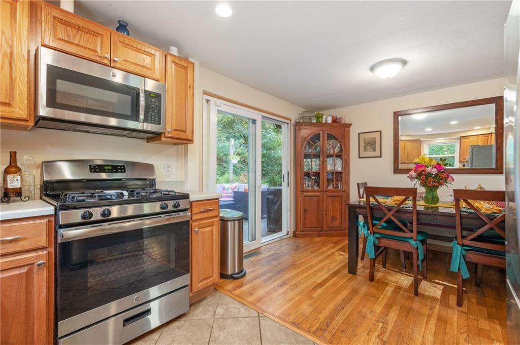 216 Hillendale Road Pittsburgh, PA 15237 - Photo 8 of 25 a kitchen with stainless steel appliances a stove a dining table and chairs with wooden floor