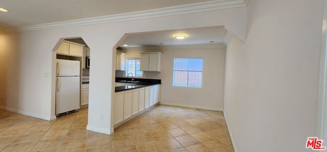 a view of kitchen with refrigerator and window