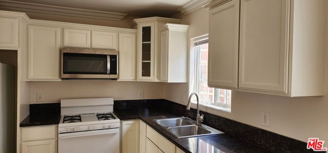 a kitchen with stainless steel appliances a stove a sink and a microwave