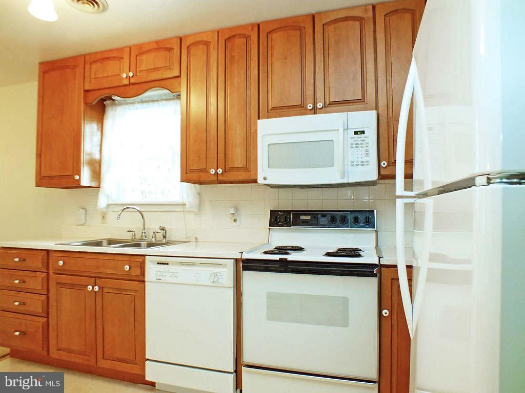 4519 Foxtail Road Hampstead, MD 21074 - Photo 6 of 29 a kitchen with stainless steel appliances granite countertop a refrigerator sink and cabinets