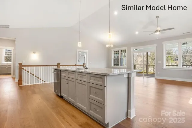 a large kitchen with kitchen island a large window and wooden floor