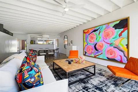 a living room filled with furniture and paintings on the wall