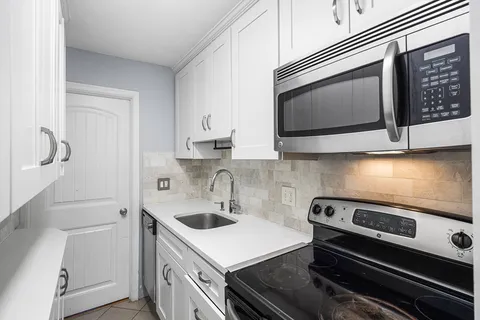 a kitchen with a sink stove and microwave