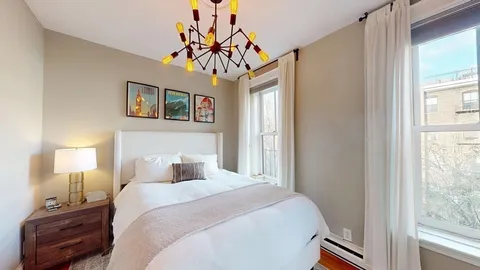 a bedroom with a bed and a chandelier