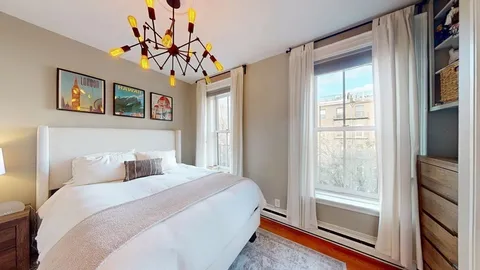 a bedroom with a large bed and a chandelier