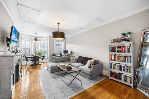 a living room with fireplace furniture and a book shelf