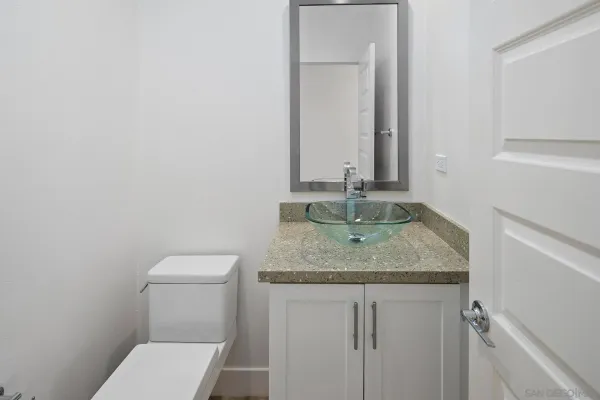 a bathroom with a granite countertop toilet and sink