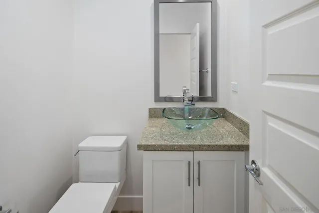 a bathroom with a granite countertop toilet and sink