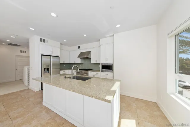 a kitchen with stainless steel appliances a refrigerator sink and microwave