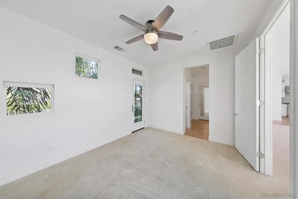an empty room with closet and ceiling fan
