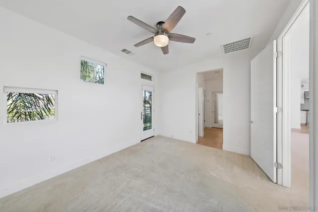 an empty room with closet and ceiling fan