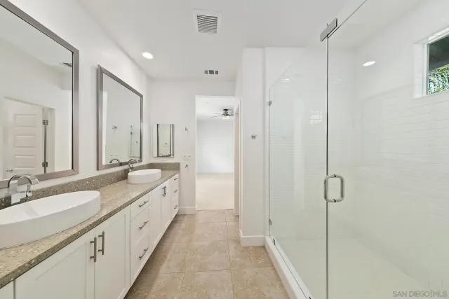 a spacious bathroom with double vanity and mirrors