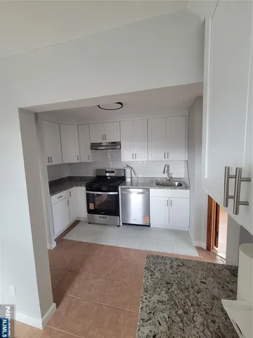 a kitchen with stainless steel appliances and white cabinets