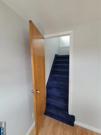 a view of a hallway with wooden floor and entryway