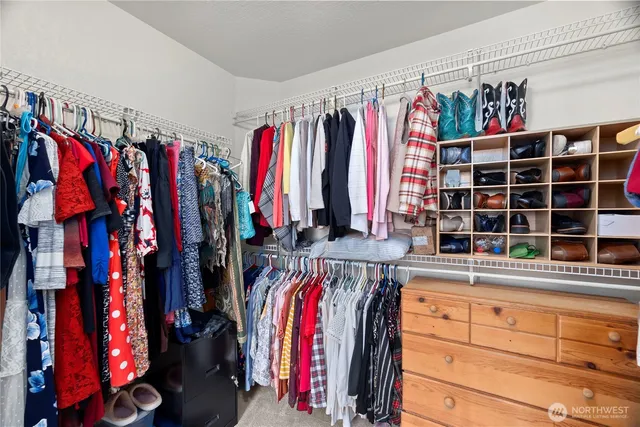 a view of walk in closet with clothes and shoes