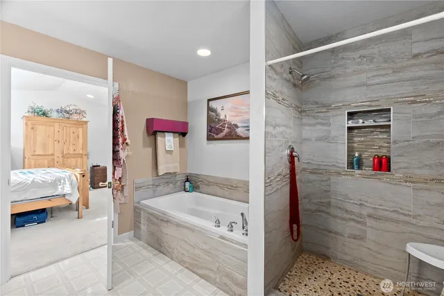 a spacious bathroom with a tub shower and mirror
