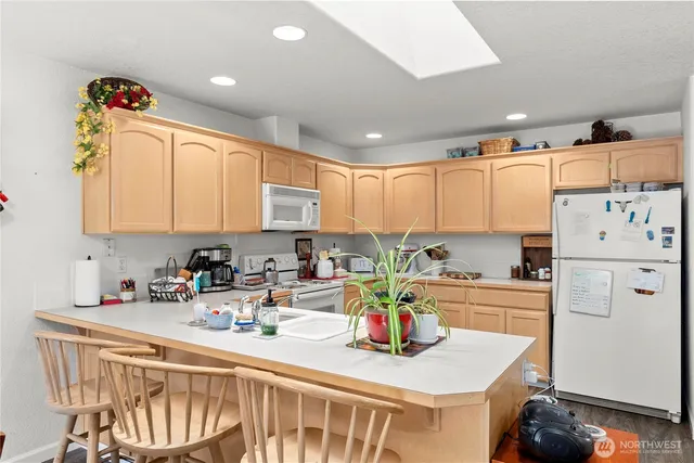 a kitchen with stainless steel appliances sink refrigerator dining table and chairs