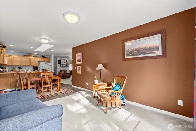a living room with furniture and a dining table with kitchen view