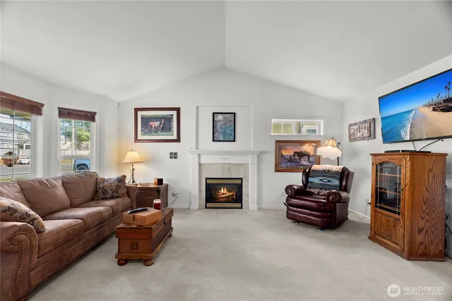a living room with furniture a fireplace and a flat screen tv