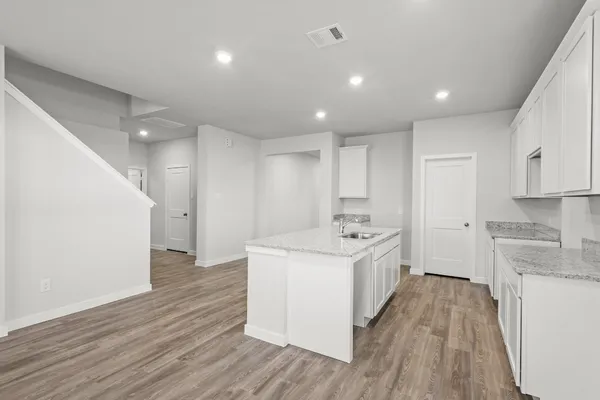 a kitchen with a sink and wooden floor