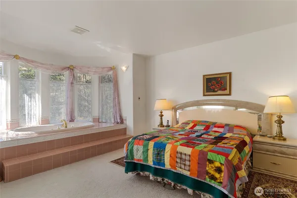 a bedroom with a bed and a flat tv screen on dresser