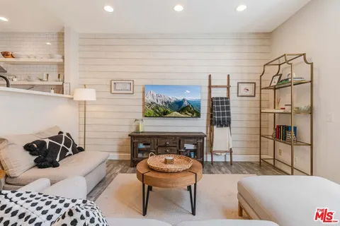 a living room with furniture a rug and a wall painting