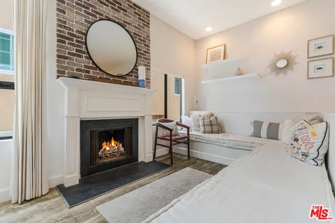 a living room with furniture a mirror and a fireplace
