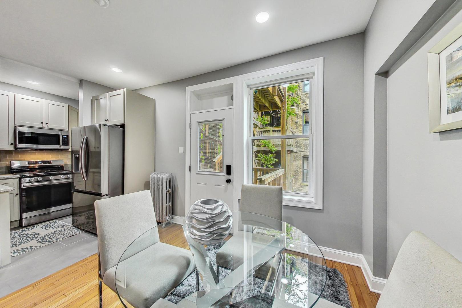 2108 North Seminary Avenue, Unit 5 Chicago, IL 60614 - Photo 7 of 16 a living room with furniture a large window and stainless steel appliances