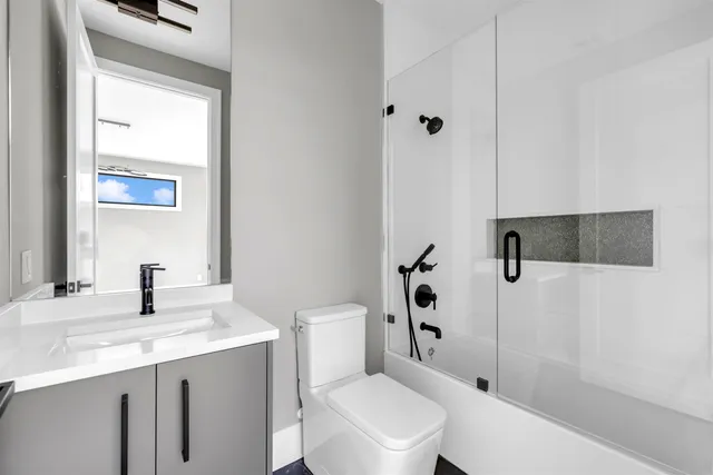 a bathroom with a sink a toilet and shower